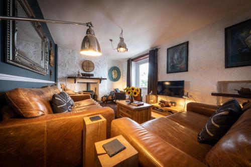 a living room with two leather couches and a television at The King's Berth in Portree
