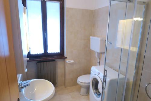 une salle de bain avec toilettes et lavabo et une machine à laver dans l'établissement Appartamento Aurora, à Molina di Ledro