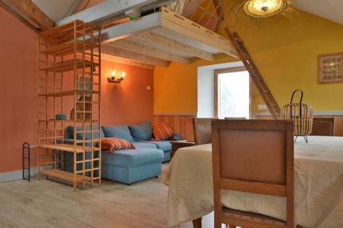 un salon avec un lit mezzanine et un canapé dans l'établissement Appartement des Cigalous, à Épinal