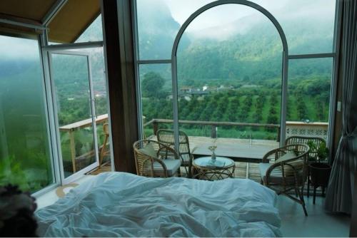 um quarto com uma cama, uma mesa e cadeiras em อาข่า พามิโอ้ em Ban Pha Mi