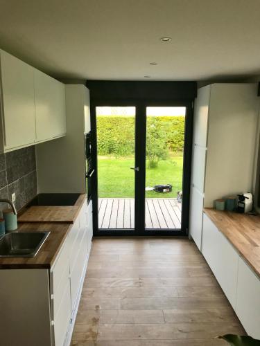 une cuisine avec une porte s'ouvrant sur une cour dans l'établissement Villa Stella plage proche Le Touquet pour 6ou8 personnes, à Cucq