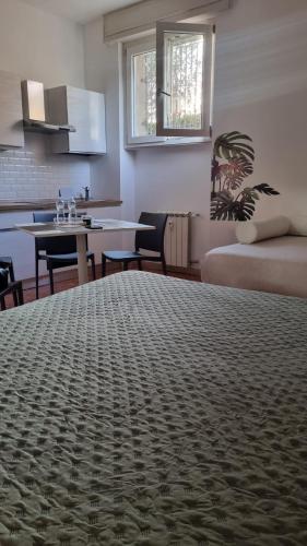 a room with a bed and a kitchen with a table at BAM BAM TIBURTINA Guesthouse in Rome