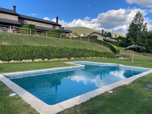 une piscine dans une cour à côté d'une maison dans l'établissement Apartamento renovado con jardín privado, parking ,wifi y piscina, à Osséja