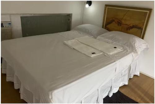 a large white bed with white sheets and pillows at Apartamento Centro do Rio de janeiro in Rio de Janeiro