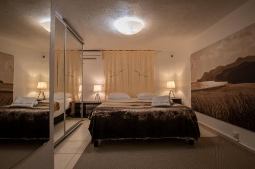 a bedroom with two beds and a mirror at Le Ponton et son spa in Saint-Mandrier-sur-Mer