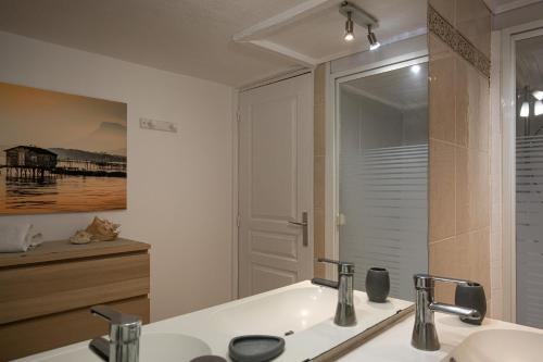 a bathroom with a sink and a mirror at Le Ponton et son spa in Saint-Mandrier-sur-Mer
