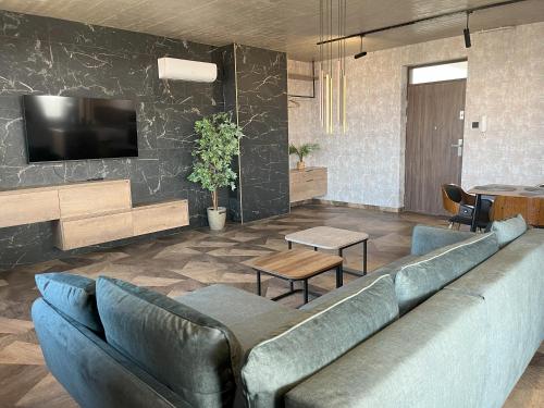 a living room with a couch and a tv at 7th Heaven in Nyíregyháza