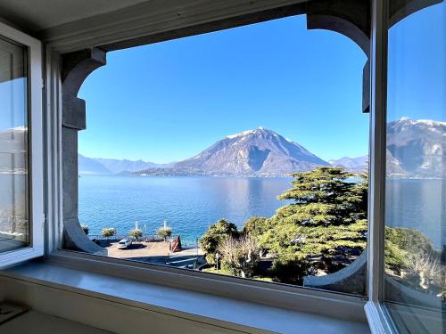 a window with a view of the water and mountains at Casa Mary Varenna in Varenna