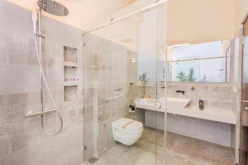 a bathroom with a shower and a toilet and a sink at Mzion Hotel Weligama in Weligama