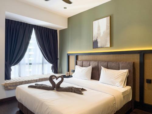 a bedroom with a bed with two swans on it at R&F Princess Cove by Nest Home at Johor Bahru in Johor Bahru