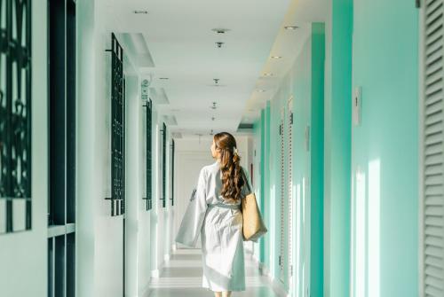 a woman walking down a hallway in a building at Wave Hotel Pattaya in Pattaya Central