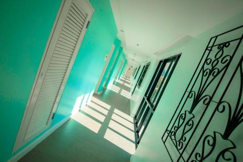 a hallway with a door and stairs with a stair railing at Wave Hotel Pattaya in Pattaya Central
