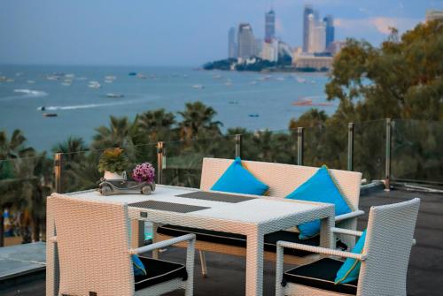 a table and chairs with a view of the water at Wave Hotel Pattaya in Pattaya Central