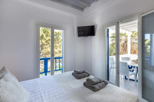 una camera da letto con un letto con due asciugamani sopra di Villa Iliana 1 & 2 w shared Pool, Ornos, Mykonos a Ornos