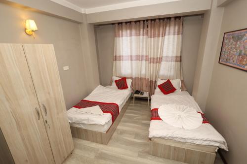 a small room with two beds and a window at Bed and Pillow Hostel in Kathmandu