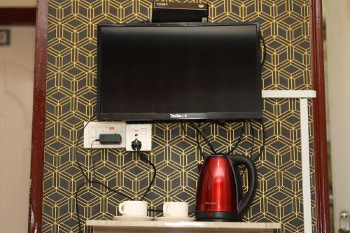 a flat screen tv on a wall with a coffee maker at Bed and Pillow Hostel in Kathmandu