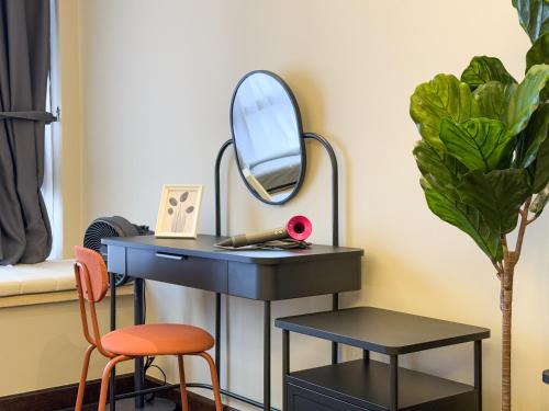 a black desk with a mirror and two chairs at R&F Princess Cove by Nest Home at Johor Bahru in Johor Bahru