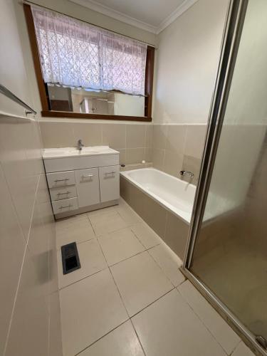 a bathroom with a tub and a sink and a shower at Bundoora cozy room in Melbourne