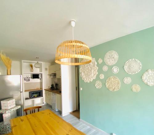 une cuisine avec une table et un lustre dans l'établissement La Cassy - Sleep in Cassis, à Cassis