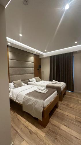 a bedroom with two beds and a window at Hotel Queen in Tirana