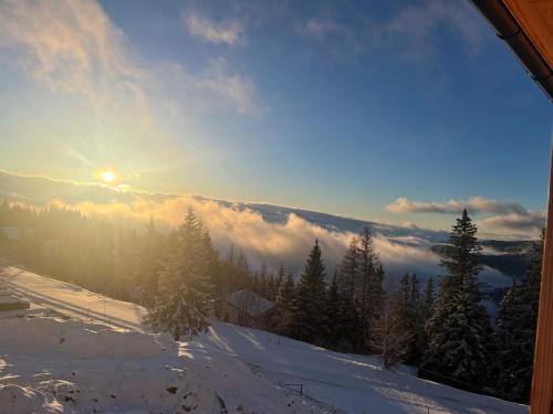 a view of the sun rising over a snow covered mountain at Appartement Weitblick in Klippitztorl