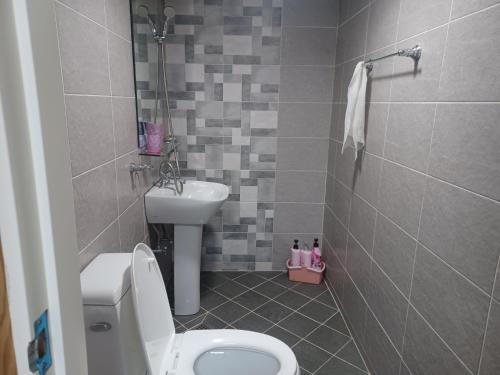 a bathroom with a toilet and a sink at Vernia in Yeosu