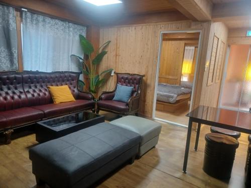 a living room with a leather couch and a table at Vernia in Yeosu