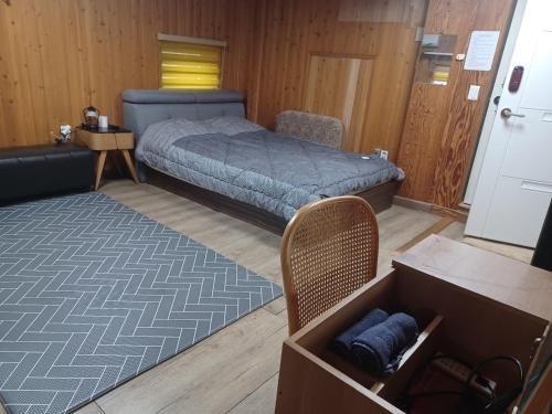a bedroom with a bed and a chair and a table at Vernia in Yeosu
