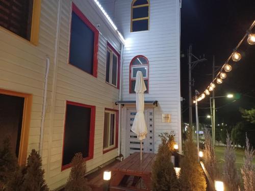 a building with an umbrella on a wooden deck at night at Vernia in Yeosu