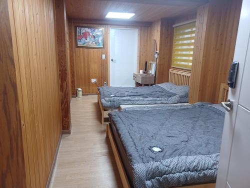 a small room with two beds and a sink at Vernia in Yeosu