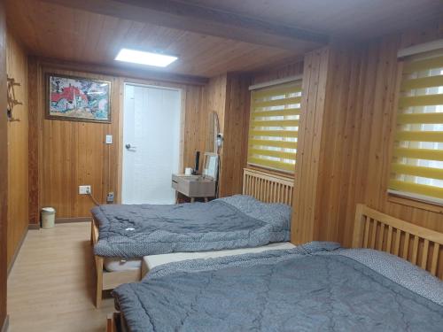 a bedroom with two beds and a sink in it at Vernia in Yeosu