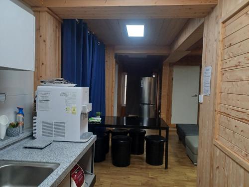 a kitchen with a table and a refrigerator in a room at Vernia in Yeosu