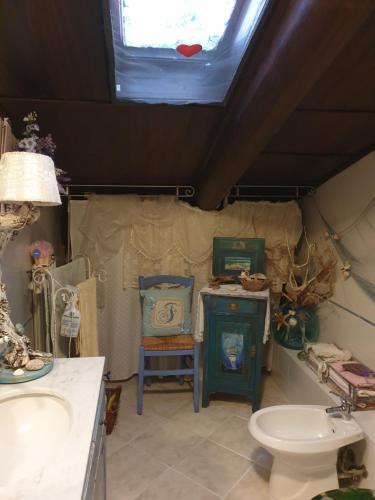 een badkamer met een wastafel en een toilet en een raam bij Creativ hause in San Giuliano Terme