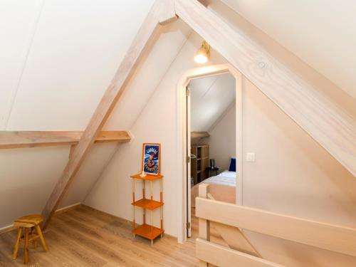 a small attic bedroom with a bed and a mirror at GLOEDNIEUW Vakantiewoning Zilt in Koksijde