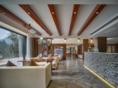 a restaurant with couches and tables in a room at Pandora Boutique Hotel---Within Zhangjiajie National Forest Park in Zhangjiajie