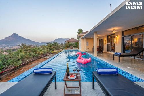 a swimming pool with a pink flamingo in a house at StayVista at Beyond Infinity with Hill View, BBQ in Lonavala
