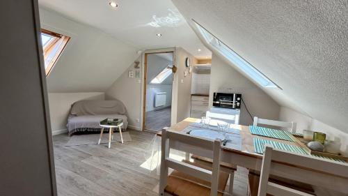 une chambre mansardée avec une table à manger et une chambre dans l'établissement Terre & Mer'veilles 2, appartement avec SPA pour 2 personnes, à Favières