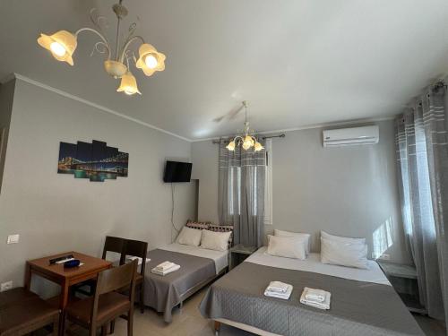 a room with two beds and a table and a dining room at Suli Apartments in Limenas