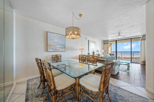 ein Esszimmer mit Glastisch und Stühlen in der Unterkunft White Caps 203 in Orange Beach