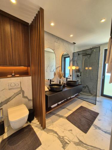 a bathroom with two sinks and a toilet in it at Pearl Penthouse in Primošten