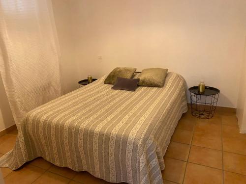 - un lit avec une couverture rayée et 2 oreillers dans l'établissement resd. cala di mare, à LʼÎle-Rousse