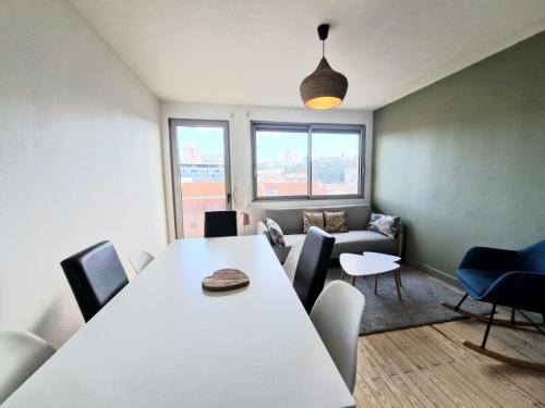 - une salle de réunion avec une table et des chaises blanches dans l'établissement Georges #Parking#Balcon, à Clermont-Ferrand