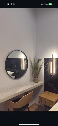 a mirror on a wall with a chair and a table at Byzantium Suite in the centre of Hermoupolis in Ermoupoli