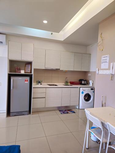 a kitchen with white cabinets and a washer and dryer at I-City I-Residence BestStudio POLOS BASRI PROPERTI in Shah Alam