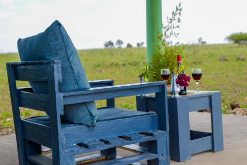 a blue chair sitting next to a table with wine glasses at Amboseli Amanya Lodge in Amboseli