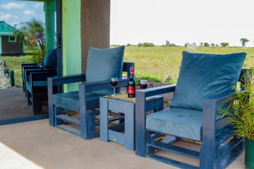 two chairs and a table with two glasses of wine at Amboseli Amanya Lodge in Amboseli