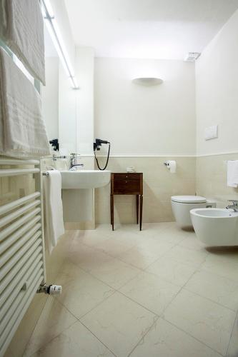 a white bathroom with a sink and a toilet at Borromeo Rooms Bed & Living in Vimercate