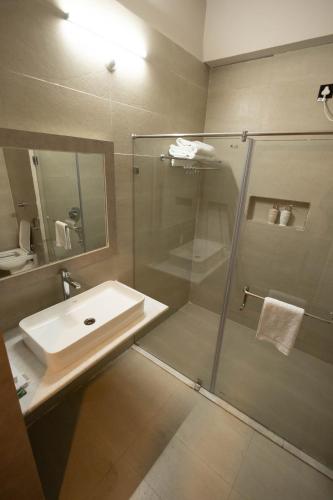 a bathroom with a glass shower and a sink at The Layover Hotel in Dimapur