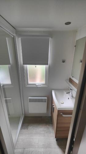 une salle de bain avec un lavabo et une fenêtre dans l'établissement Mobile-Home 6-8 personnes - camping 