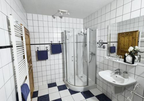 une salle de bain carrelée blanche avec une douche et un lavabo dans l'établissement Ferienhof-Wohler-Wohnung-4, à Bojendorf